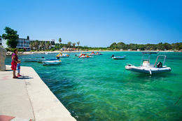 Kotviště člunů u písčitooblázkové pláže u hotelu Liberty, Novalja, ostrov Pag, Chorvatsko