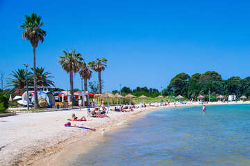 Novalja - písčitooblázková pláž ve městě u hotelu, ostrov Pag, Chorvatsko