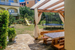 Apartmány Mimoza - venkovní posezení, dětské houpačky, skluzavka i trampolína v zahradě, Lopar, ostrov Rab, Chorvatsko