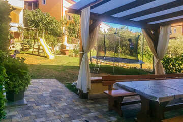 Apartmány Mimoza - venkovní posezení, dětské houpačky, skluzavka i trampolína v zahradě, Lopar, ostrov Rab, Chorvatsko