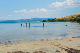 Posedarje - pohled na písečnou pláž na ostrůvku s kostelíkem, Zadarská riviéra, Chorvatsko