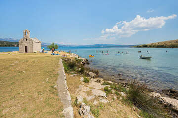 Písečná pláž na ostrůvku s kostelíkem Sv. Duha, Posedarje, Zadarská riviéra, Chorvatsko
