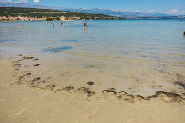 Písečná pláž na ostrůvku s kostelíkem Sv. Duha, Posedarje, Zadarská riviéra, Chorvatsko