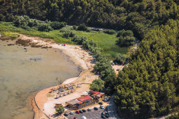 Pláž a parkoviště před ostrůvkem s kostelíkem Sv. Duha - letecký pohled, Posedarje, Zadarská riviéra, Chorvatsko