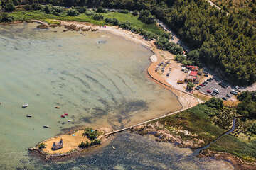 Pláž a parkoviště před ostrůvkem s kostelíkem Sv. Duha - letecký pohled, Posedarje, Zadarská riviéra, Chorvatsko