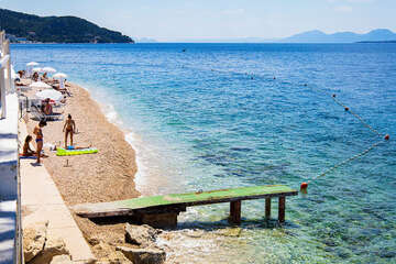 Letovisko Igrane - veřejná oblázková pláž pod hotelem (lehátka patří hotelu), Makarská riviéra, Chorvatsko