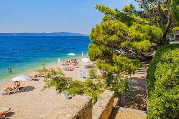Letovisko Igrane - veřejná oblázková pláž pod hotelem (lehátka patří hotelu), Makarská riviéra, Chorvatsko