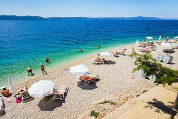 Letovisko Igrane - veřejná oblázková pláž pod hotelem (lehátka patří hotelu), Makarská riviéra, Chorvatsko