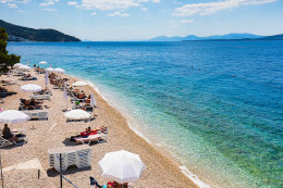 Letovisko Igrane - veřejná oblázková pláž pod hotelem (lehátka patří hotelu), Makarská riviéra, Chorvatsko