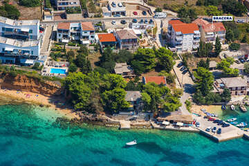 Apartmány Bracera - letecký pohled na dům a písečnou pláž (vlevo na fotce), Stará Novalja, ostrov Pag, Chorvatsko