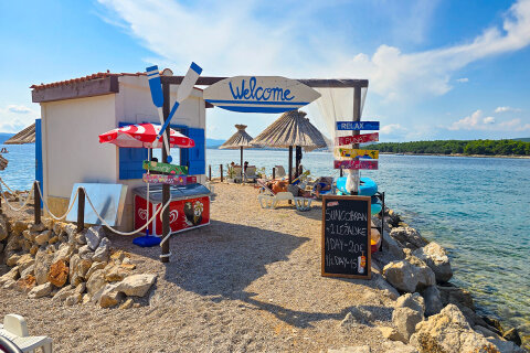 Punat - půjčovna lehátek a slunečníků u pláže, ostrov Krk, Chorvatsko